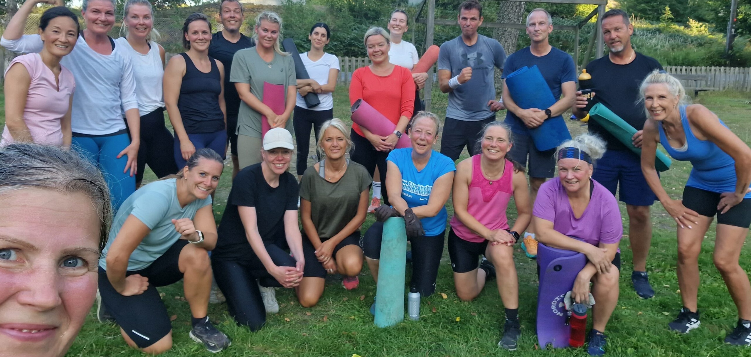 En grupp människor ler mot kameran efter ett svettigt träningspass.